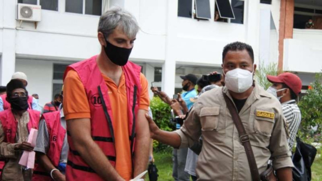 Seorang petugas Kejaksaan Tinggi Provinsi Nusa Tenggara Timur mengiring warga Italia, Masimiliano De Reviziis (kiri), saat ditahan oleh penyidik Kejaksaan beberapa waktu lalu.