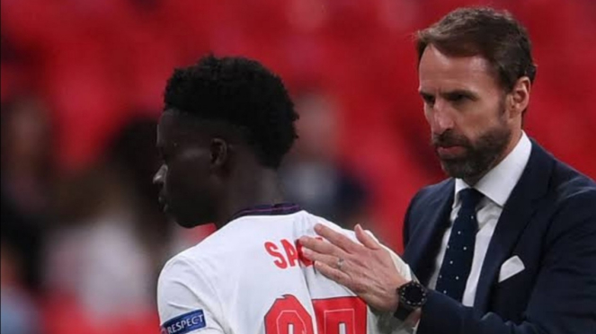 Pelatih Inggris Gareth Southgate menenangkan Bukayo Saka. 