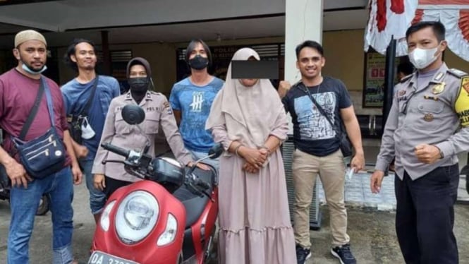 Polisi memperlihatkan seorang perempuan berkerudung, residivis pencurian, yang berhasil ditangkap setelah aksi kejar-kejaran dengan sepeda motor di jalan raya di Kota Banjarbaru, Kalimantan Selatan, Kamis, 15 Juli 2021.