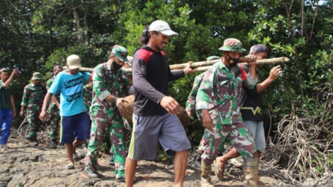 Polisi dibantu prajurit TNI dan warga mengevakuasi sebuah bom sisa Perang Dunia II yang ditemukan di area tambak warga Dusun Cumene, Desa Sumpang Minangae, Kecamatan Sibulue, Kabupaten Bone, Sulawesi Selatan, Sabtu, 24 Juli 2021.