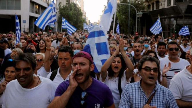 Para pengunjuk rasa meneriakkan berbagai slogan saat berdemonstrasi untuk menentang vaksinasi penyakit virus corona (COVID-19) di Athena, Yunani, Sabtu, 24 Juli 2021.