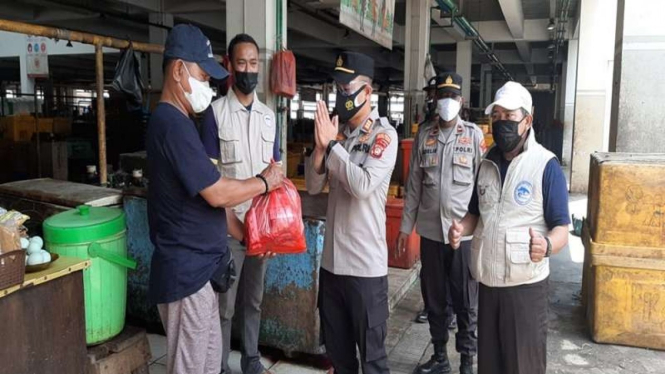 Polisi membagikan bansos PPKM level 4 di Jakarta