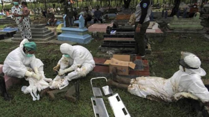 Petugas beristirahat setelah memakamkan jenazah dengan protokol COVID-19 di Tempat Pemakaman Umum (TPU) Kelurahan Paoman, Indramayu, Jawa Barat, Kamis, 24 Juli 2021.