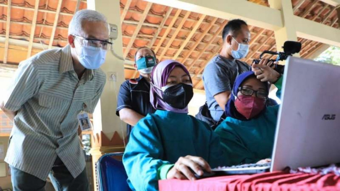 Gubernur Jawa Tengah Ganjar Pranowo memeriksa penginputan data digital vaksin COVID-19 oleh sejumlah tenaga kesehatan di Kabupaten Grobogan, Selasa, 3 Agustus 2021.
