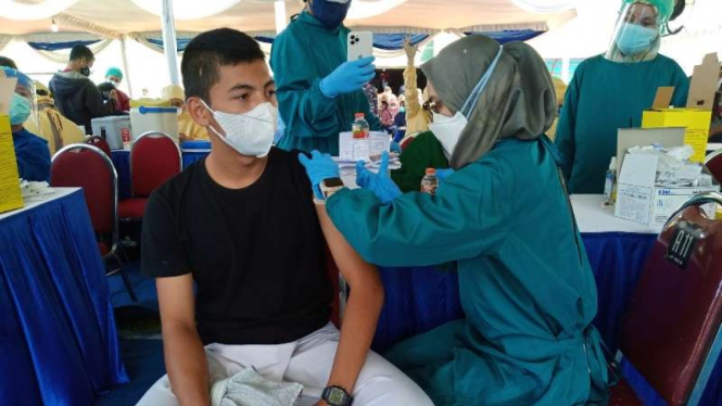 Seorang remaja disuntik vaksin COVID-19 oleh tenaga kesehatan dalam kegiatan yang dinamai serbuan vaksin dan difasilitasi oleh Komando Armada II TNI AL di Stadion Gajayana, Kota Malang, Jawa Timur, Sabtu, 7 Agustus 2021.