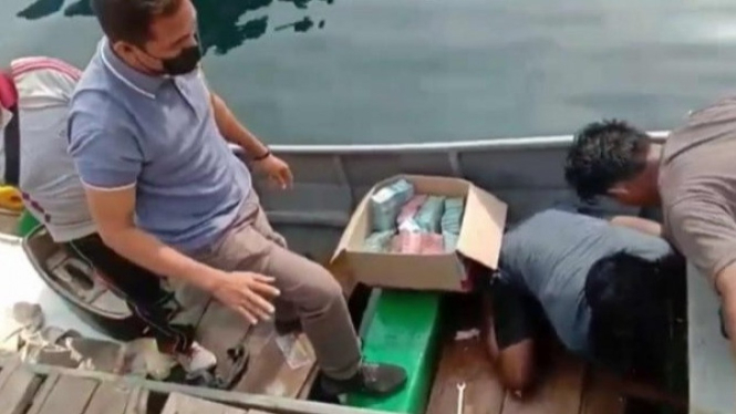 Petugas dan Nelayan Kumpulkan Uang yang Tercecer akibat Tabrakan Speedboat di Halmahera.