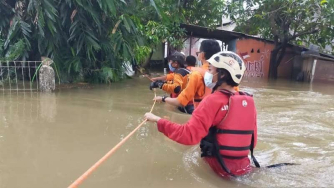 Petugas BPBD mengevakuasi warga yang terdampak banjir akibat luapan air Kali Ulu di Desa Tanjung Sari dan Karang Raharja, Kecamatan Cikarang Utara, Kabupaten Bekasi, Jawa Barat, Selasa siang, 10 Agustus 2021.