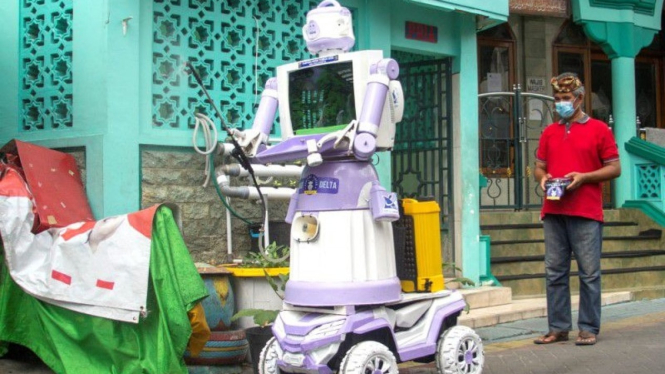 Aseyanto, warga Tembok Gede, mengoperasikan "Robot Delta", yang terbuat dari barang-barang rumah tangga bekas seperti panci, wajan, dan monitor televisi tua, di Surabaya, Jawa Timur, Indonesia (07/08/2021). (Supplied:Â REUTERS/Prasto Wardoyo)