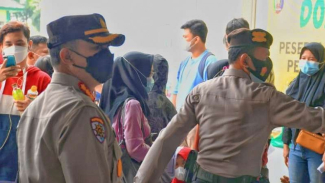 Kepolisian Resor Kota Bandarlampung menertibkan kerumunan pada pelaksanaan vaksinasi massal bagi masyarakat umum di RSUD Abdoel Moelok (RSUDAM) Provinsi Lampung, Kamis, 12 Agustus 2021.