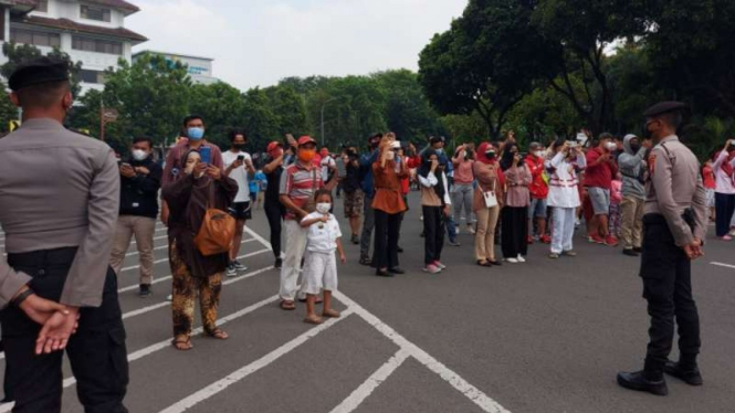 Sejumlah warga DKI Jakarta menikmati atraksi terbang lintas (flypast) pesawat tempur TNI Angkatan Udara di Jalan Majapahit, Jakarta Pusat, Selasa, 17 Agustus 2021.