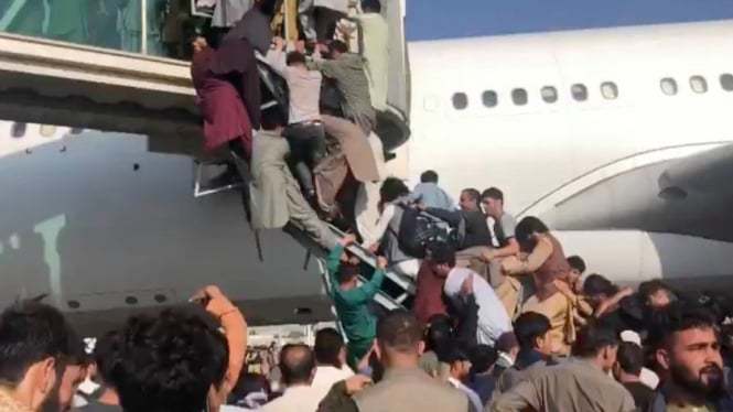 Sekelompok orang mencoba menaiki tangga di Terminal Bandara Kabul, setelah gerilyawan Taliban menguasai istana presiden di Kabul, 16 Agustus 2021. (Twitter:Â Sudhir Chaudhary)