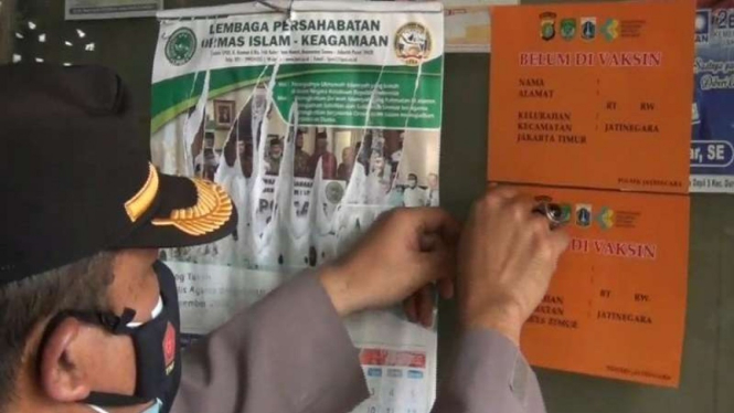 Polisi menempelkan stiker di rumah warga di DKI Jakarta yang belum divaksin
