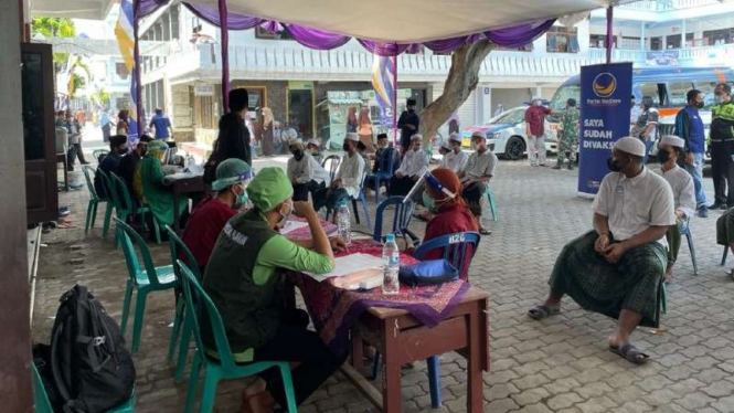 Sejumlah warga mengantre untuk disuntik vaksin COVID-19 dalam kegiatan vaksinasi secara massal di Pesantren Zainul Hasan Genggong, Kabupaten Probolinggo, Jawa Timur, Sabtu, 21 Agustus 2021.