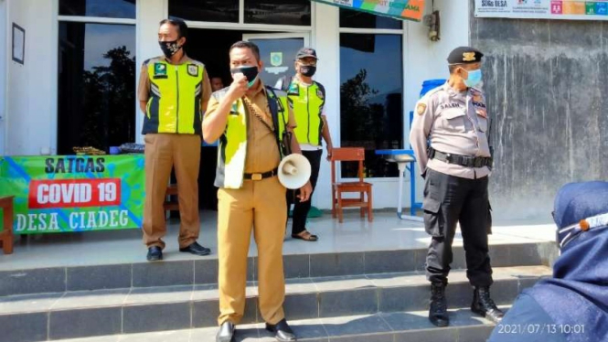 Kepala Desa Ciadeg Wahyu Rahayu di Kecamatan Cigombong, Kabupaten Bogor, Jawa Barat, menyampaikan pengumuman kepada warga mengenai upaya mengantisipasi penularan COVID-19, Selasa, 24 Agustus 2021.