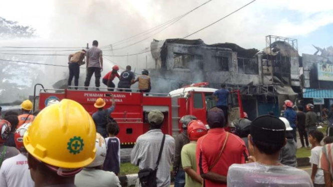 Petugas pemadam kebakaran dari BPBD Mimika dibantu Polres Mimika berupaya memadamkan api yang membakar delapan ruko di Jalan Yos Sudarso, Timika, Rabu, 25 Agustus 2021.