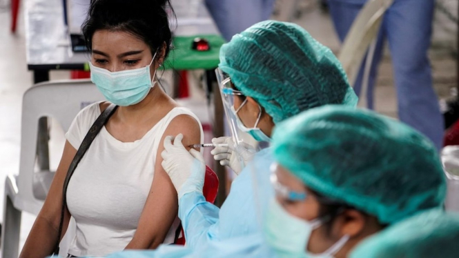 Seorang perempuan di BangkokÂ menerima vaksin CoronaVac produksiÂ Sinovac setelah ratusan penduduk di distrik tersebut dinyatakan positif COVID-19 pada April lalu. (Supplied:Â REUTERS/Athit Perawongmetha)