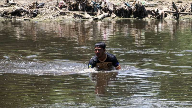 Petugas mengambil sampel air sungai Bengawan Solo yang tercemar