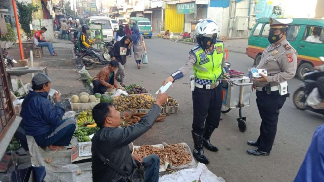 Polisi membagikan masker kepada pedagang di Bandung, Jabar.