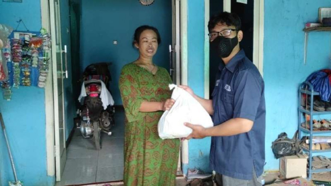 Seorang warga Desa Warnaherang, Kecamatan Gunungputri, Kabupaten Bogor, Jawa Barat, menerima paket sembako dan masker untuk pencegahan penularan COVID-19 dari PT Mitra Tata Lingkungan Baru (MTLB), Rabu, 22 September 2021.