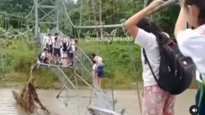 Viral pelajar SMP ke sekolah menyebrangi jembatan rusak.