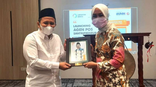 Direktur Bisnis Kurir dan Logistik PT Pos Indonesia Siti Choiriana (kanan) bersama pimpinan Komunitas Santripreneur Indonesia usai menandatangani kesepakatan kerja sama, Jumat, 1 Oktober 2021, ekspansi jaringan bisnis kurir dan logistik di daerah.