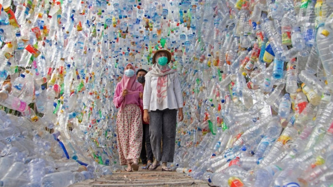 Pengunjung melewati Terowongan 4444 yang dibuat semuanya dari botol plastik yang dikumpulkan dari sungai-sungai di sekitar Gresik selama tiga tahun. (REUTERS/Prasto Wardoyo)