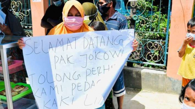 Ibu-ibu di Sorong bentangkan spanduk ke Jokowi.