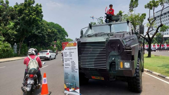 Warga naik alutsista TNI yang dipamerkan di kawasan Medan Merdeka Jakarta 