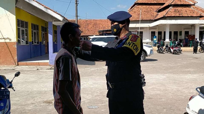 Polda Jabar membagikan masker kepada warga di Cirebon, Jabar.