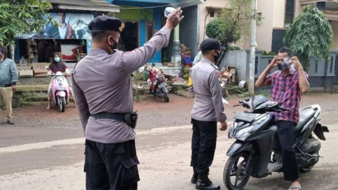 Polisi menghentikan seorang pengendara sepeda motor di Kabupaten Majalengka, Jawa Barat, Selasa, 19 Oktober 2021, untuk memperingatkan warga itu agar mengenakan masker untuk mencegah penularan COVID-19.