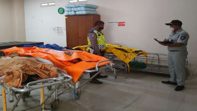 Polisi dan petugas PT Jasa Raharja memeriksa jenazah-jenazah korban kecelakaan lalu lintas di Jalan Raya Bandung-Cirebon Cijanggel, Desa Cinanjung, Kecamatan Tanjungsari, Kabupaten Sumedang, Jawa Barat, 7 November 2021.