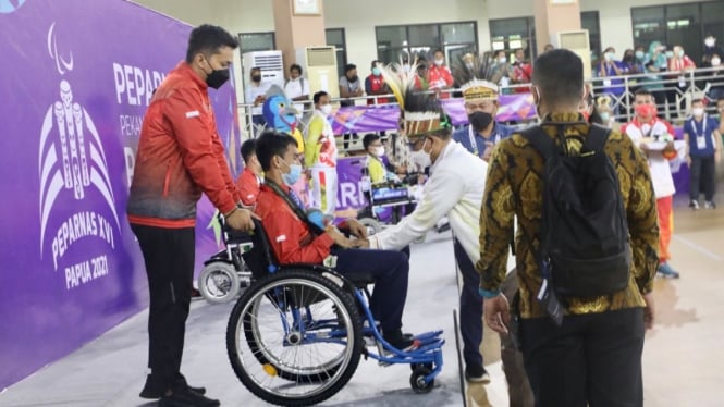 Menkopolhukam Mahfud MD mengalungkan medali ke peserta Peparnas Papua.