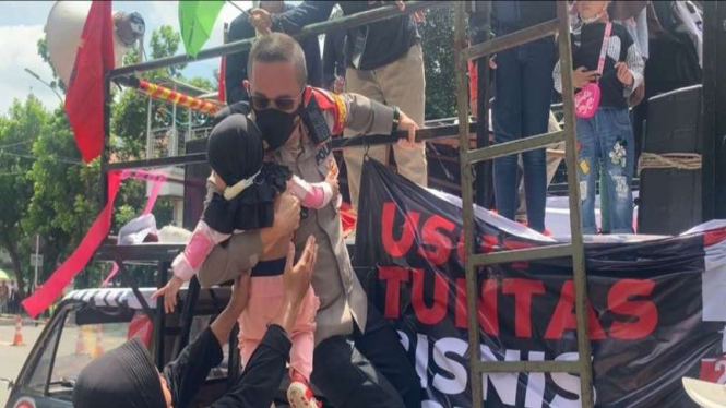 Kapolsek Setiabudi Kompol Beddy Suwendi menurunkan balita saat aksi di KPK