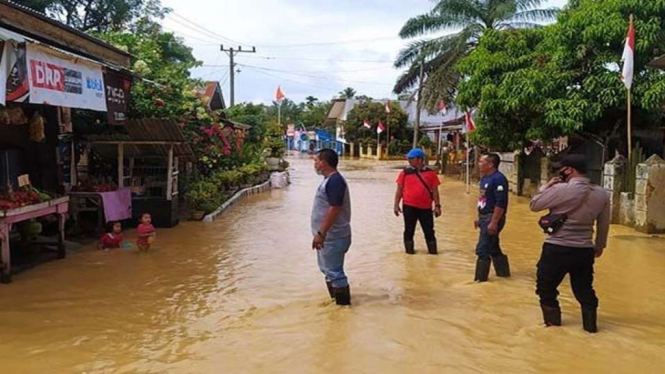 Dokumentasi - Warga melintas di genangan air di Indra Makmur Kabupaten Aceh Timur.