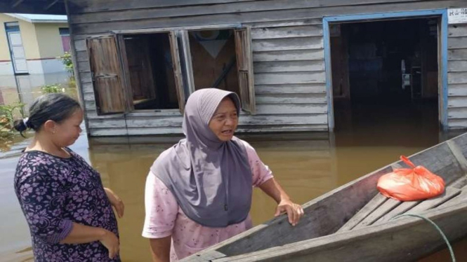 Dua warga beraktivitas dengan perahu selagi rumah mereka terendam banjir yang melanda permukiman mereka di Kecamatan Jongkong, Kabupaten Kapuas Hulu, Kalimantan Barat, Selasa, 23 November 2021.