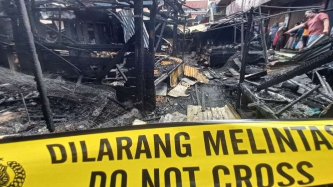 Polisi memasang police line di sekitar bangunan Pasar Bawah, Kota Bukittinggi, Sumatera Barat, yang terbakar pada Rabu dini hari, 24 November 2021.