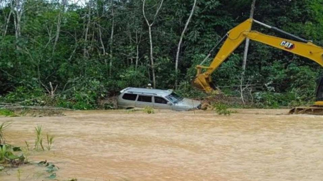 Mobil milik pasangan suami istri yang terseret air banjir di jalan hauling PT Palopo, wilayah Barito Selatan, Kabupaten Barito Utara, Kalimantan Tengah, dievakuasi pada Rabu, 24 November 2021.