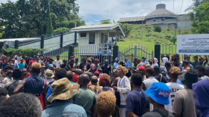 Warga Kepulauan Solomon berkumpul di depan gedung Parlemen di Honiara, menuntut pengunduran diri Perdana Menteri Manasseh Sogavare. (ABC News:Â Evan Wasuka)