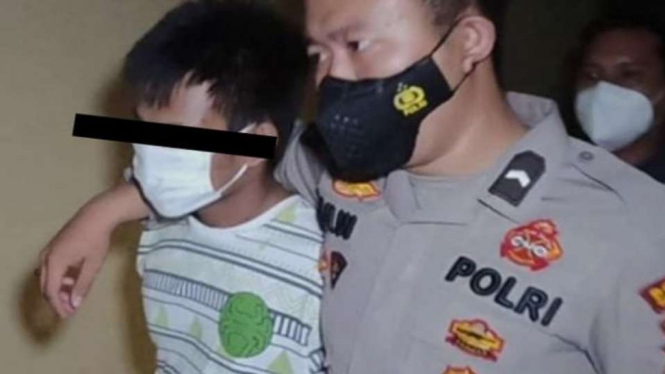Polisi menggelandang seorang pemuda tersangka pembunuh berantai lima orang warga di Kampung I, Desa Sungai Bunglai, Kecamatan Peninjauan, Kabupaten Ogan Komering Ulu, Sumatera Selatan, Jumat, 26 November 2021.