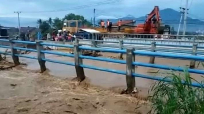 Kereta pengangkut alat berat membersihkan rel kereta yang tergenang banjir di Bandung, Jawa Barat, Sabtu, 27 November 2021.