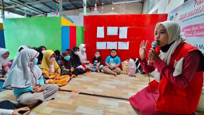 Seorang pendongeng sedang berceritera di depan anak-anak.