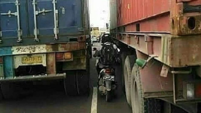 Naik Motor di Dekat Truk.