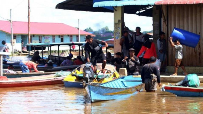 Warga berada di atas perahu motor di jalan raya Pasar Sungai Durian, Kabupaten Sintang, Kalimantan Barat, Senin, 22 November 2021.