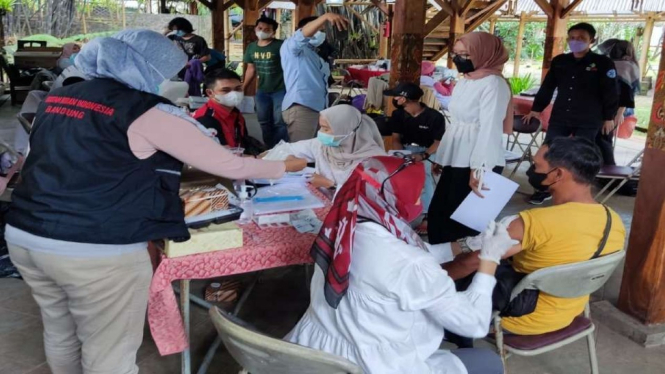 Kegiatan vaksinasi COVID-19 dosis kedua yang diselenggarakan oleh Perhimpunan Taman Rekreasi Indonesia (Putri) Jawa Barat di Saung Angklung Udjo, Padasuka, Bandung.