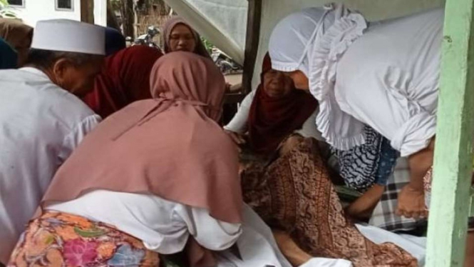 Sejumlah warga mengurus jenazah korban banjir bandang disertai longsor yang terjadi di Dusun Batulayar Utara, Desa Batulayar, Lombok Barat, Nusa Tenggara Barat, Senin, 6 Desember 2021.