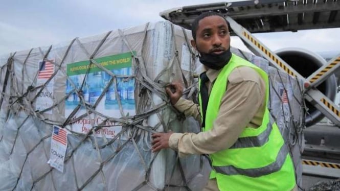 Seorang pekerja terminal Ethiopian Airlines Cargo menurunkan pengiriman vaksin virus corona (COVID-19) Johnson & Johnson's yang tiba di bawah skema COVAX di Bandara Internasional Bole di Addis Ababa, Ethiopia, Senin, 19 Juli 2021.