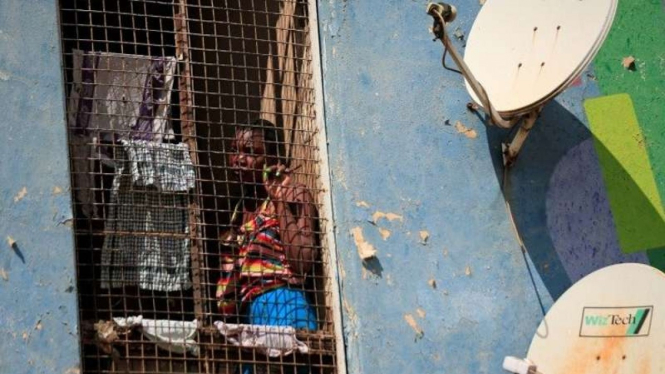 Seorang wanita menengok dari blok apartemen pada masa lockdown di Zimbabwe-Arsip