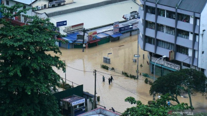 Warga melintasi banjir di Jalan Thamboosamy, Kuala Lumpur.