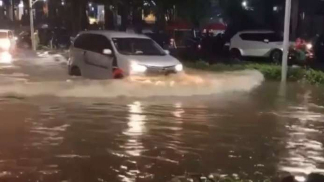 Sebuah mobil berusaha menerjang banjir di Jalan Kemang Raya, Jakarta Selatan.