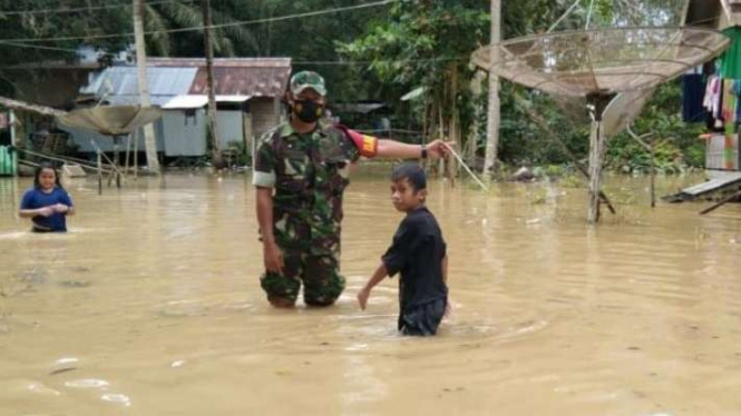 Personil Babinsa Kelurahan Pemaluan, Kecamatan Sepaku, Kabupaten Penajam Paser Utara, Kalimantan Timur, memantau kondisi banjir di Pemaluan, Kamis, 30 Desember 2021.